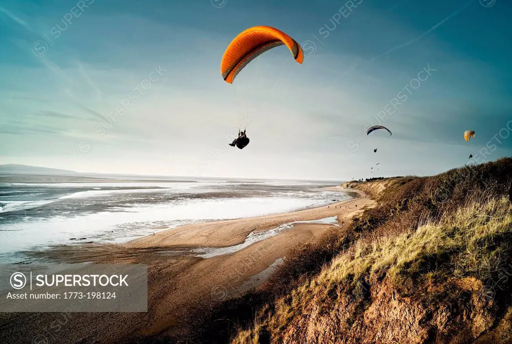 Hang gliders over beach