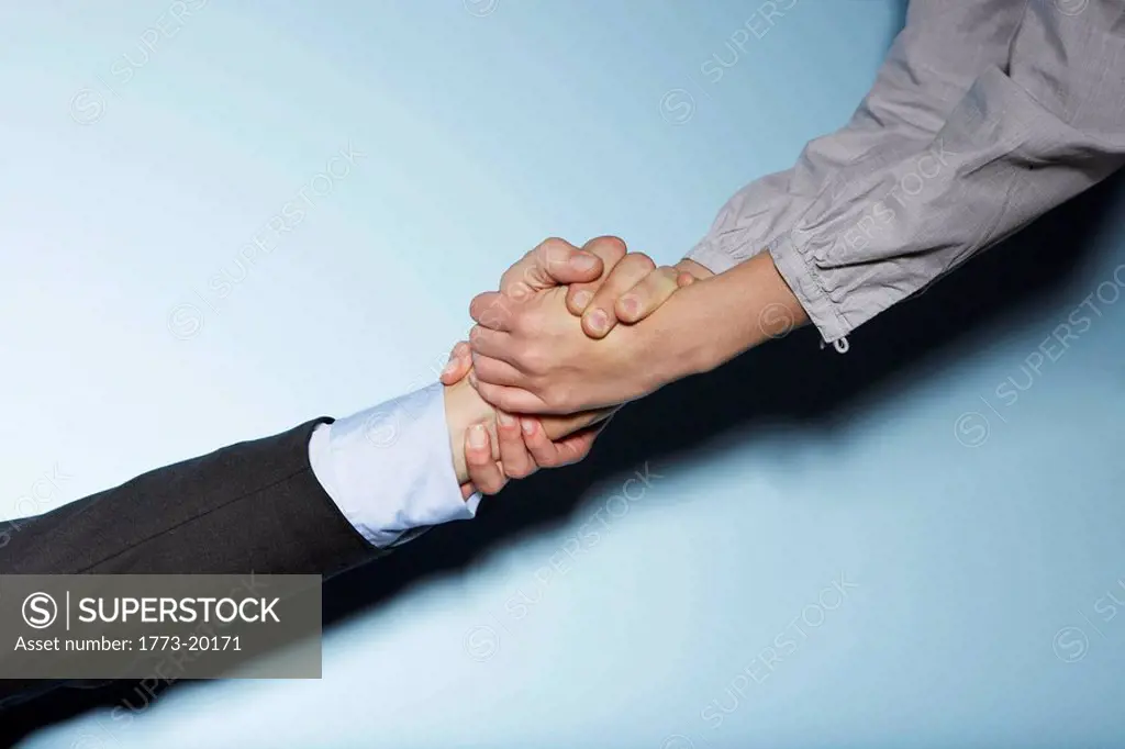 A close up of a business man being helped up by business woman