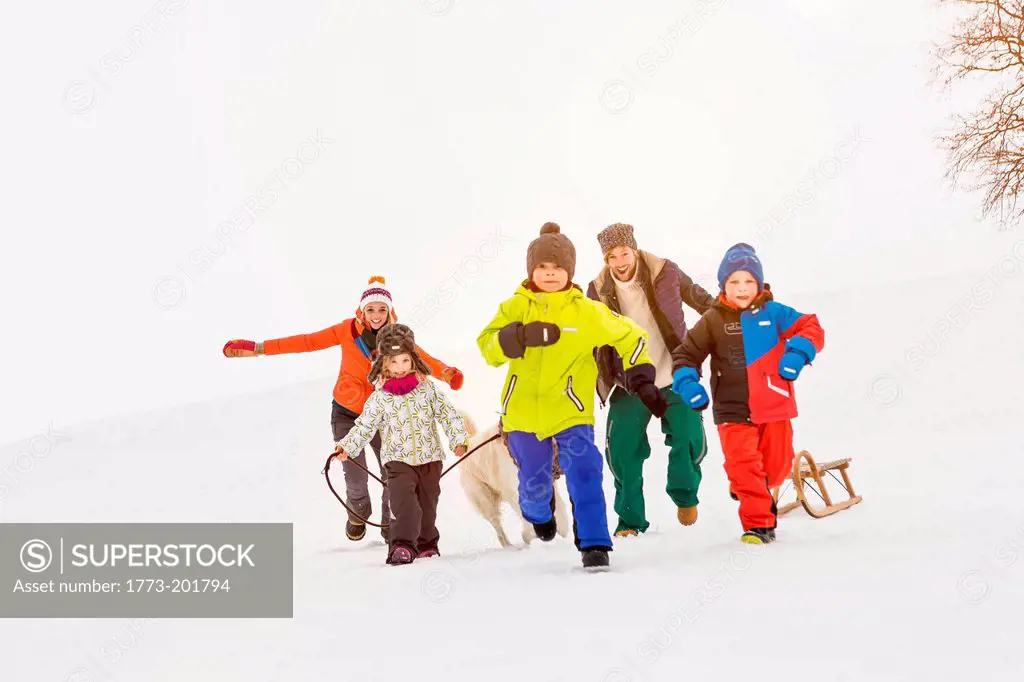 Family with three children running in snow
