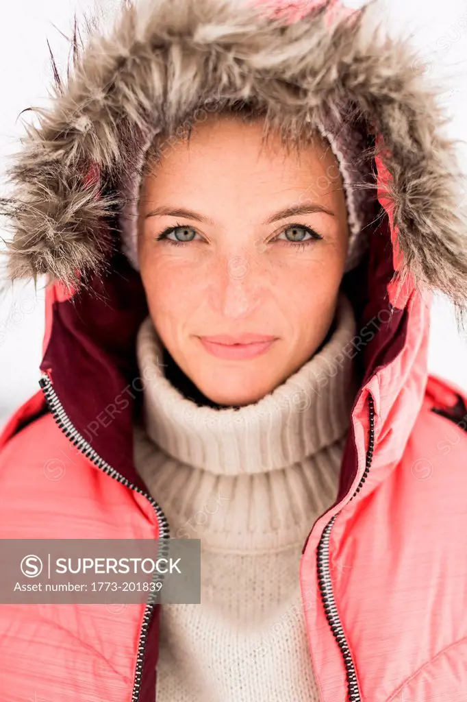 Portrait of woman wearing pink ski jacket with hood