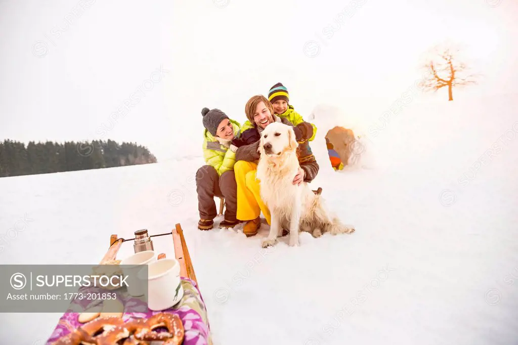 Parents and son with dog in snow