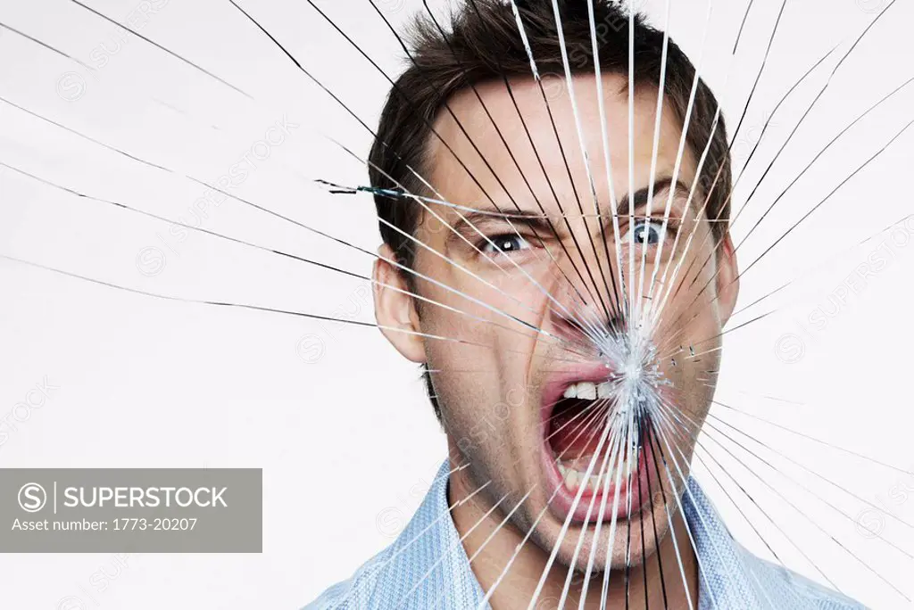 Young man behind cracked glass shouting