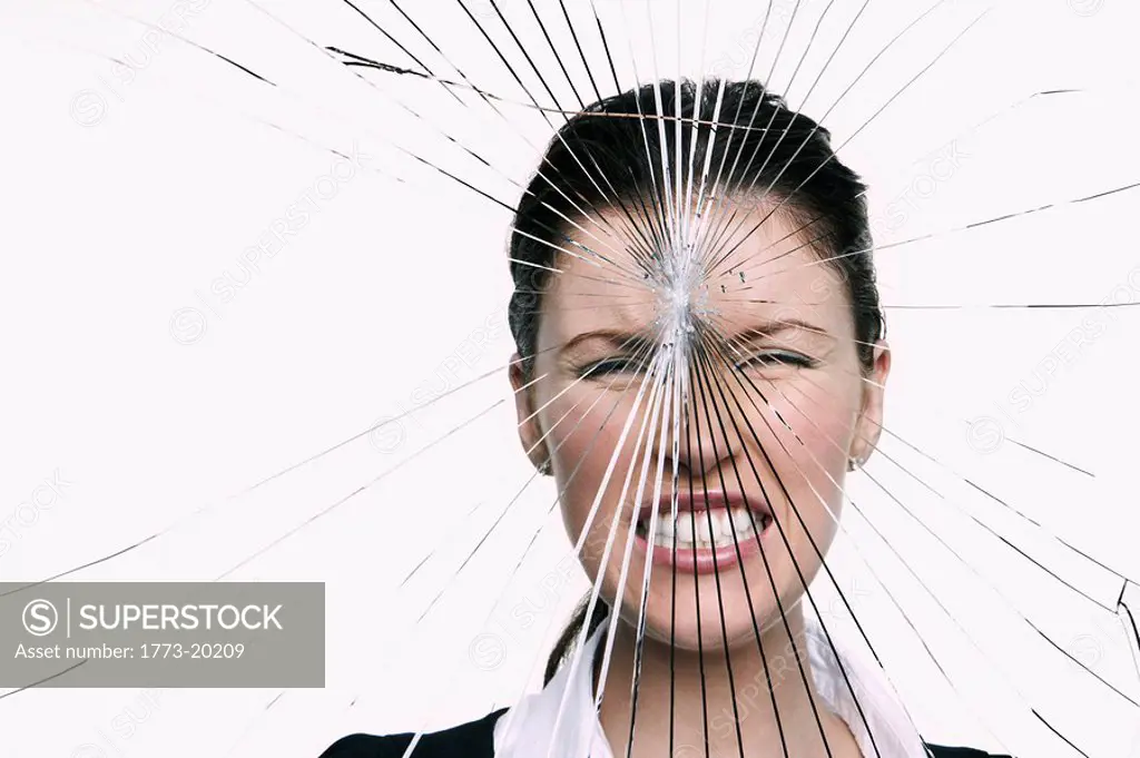 Young woman behind cracked glass