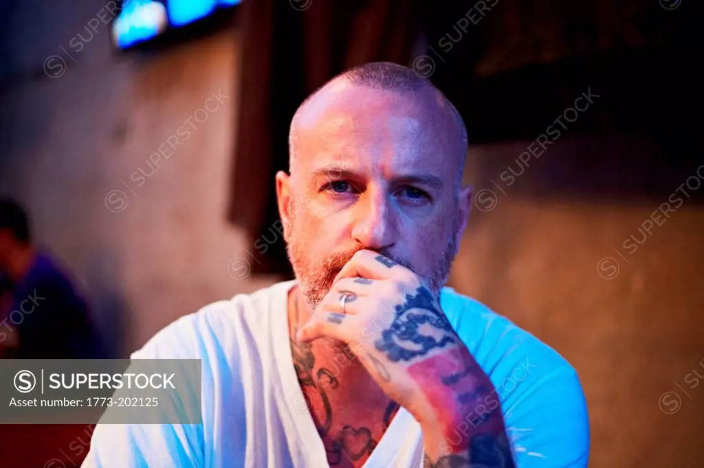 Man with shaved head and tattoos