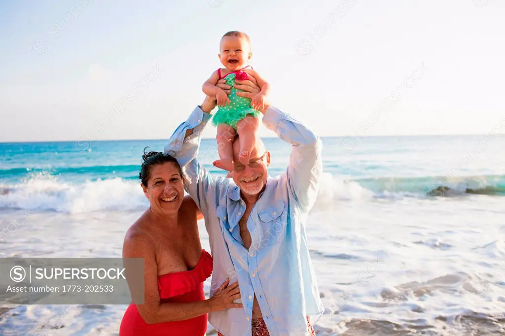 Grandparents with grandfather lifting granddaughter, St Maarten, Netherlands
