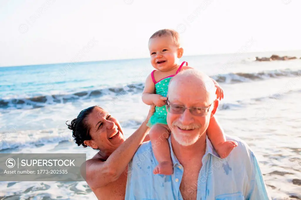 Grandparents with granddaughter on grandfather's shoulders, St Maarten, Netherlands