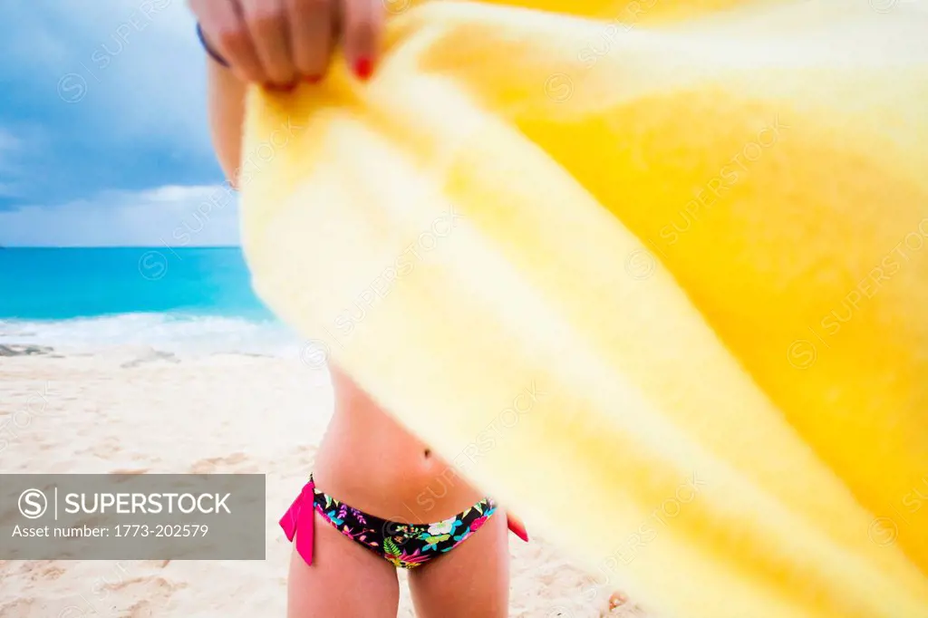 Woman holding yellow towel on beach, St Maarten, Netherlands