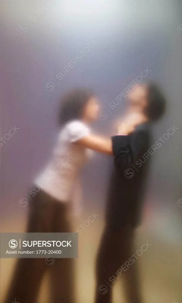 Blurred image of woman trying to strangle male co_worker. Seen through frosted office screen.