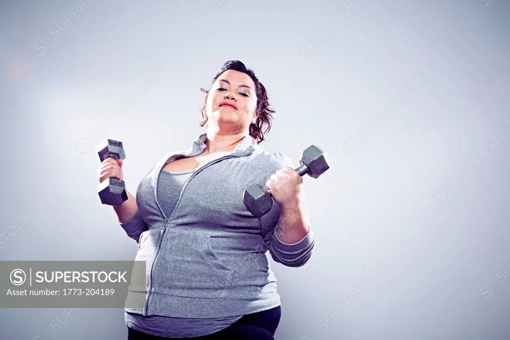 Mid adult woman using hand weights