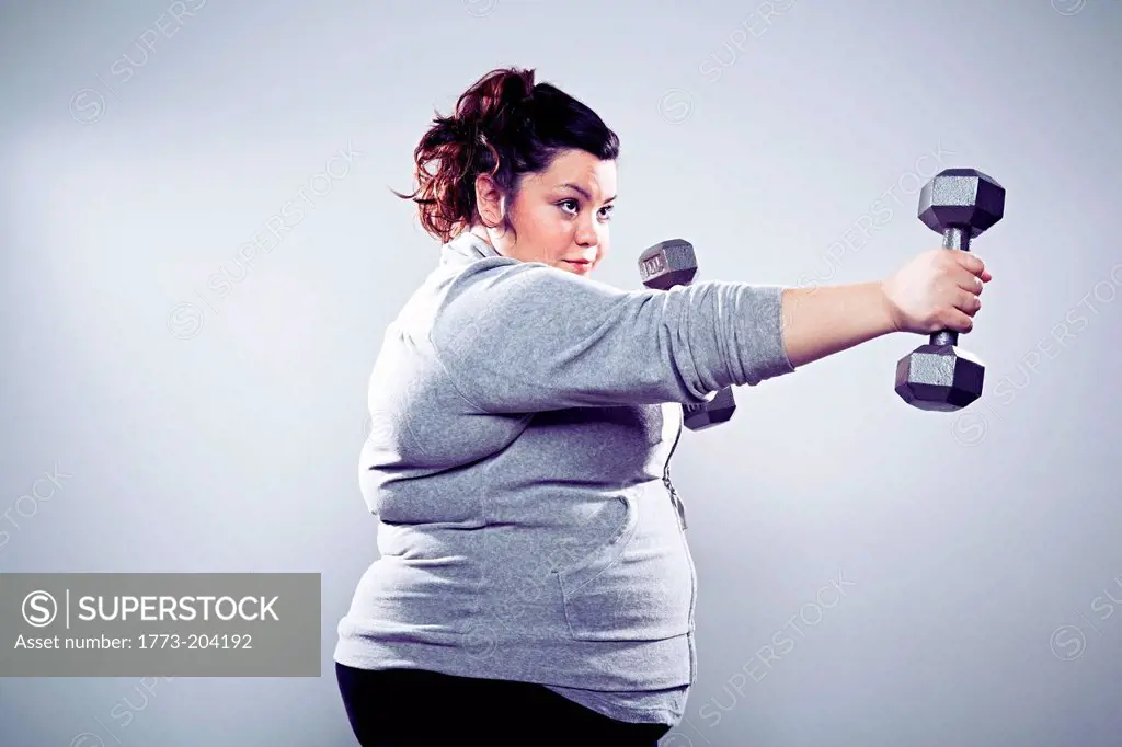 Mid adult woman using hand weights