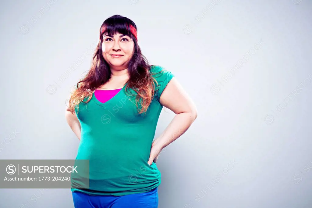 Mid adult woman wearing green t shirt, hands on hips