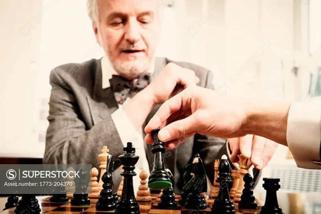 Two men playing chess in office