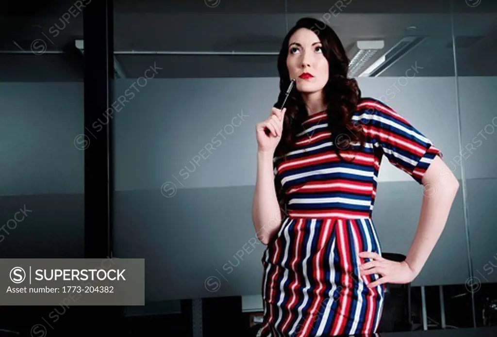 Business executive pondering with hand on hip