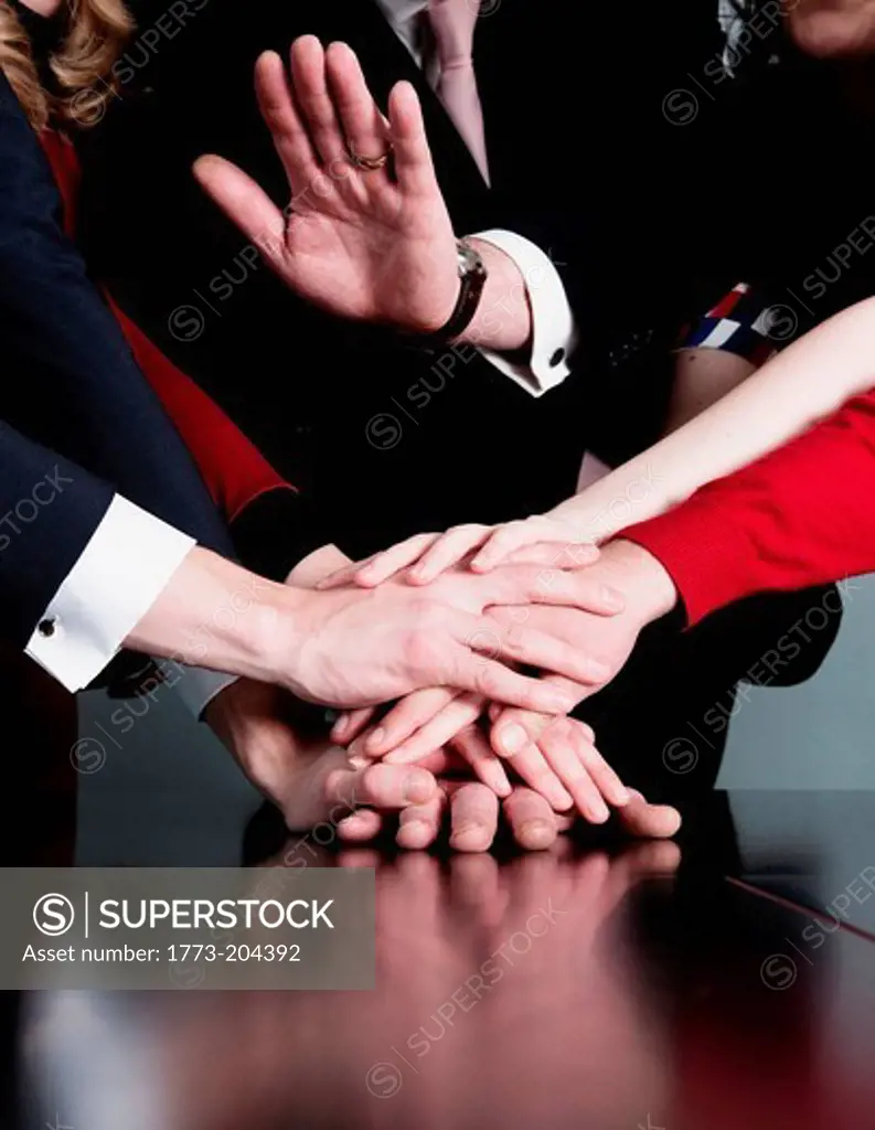 Closeup of business team putting their hands on top of each other