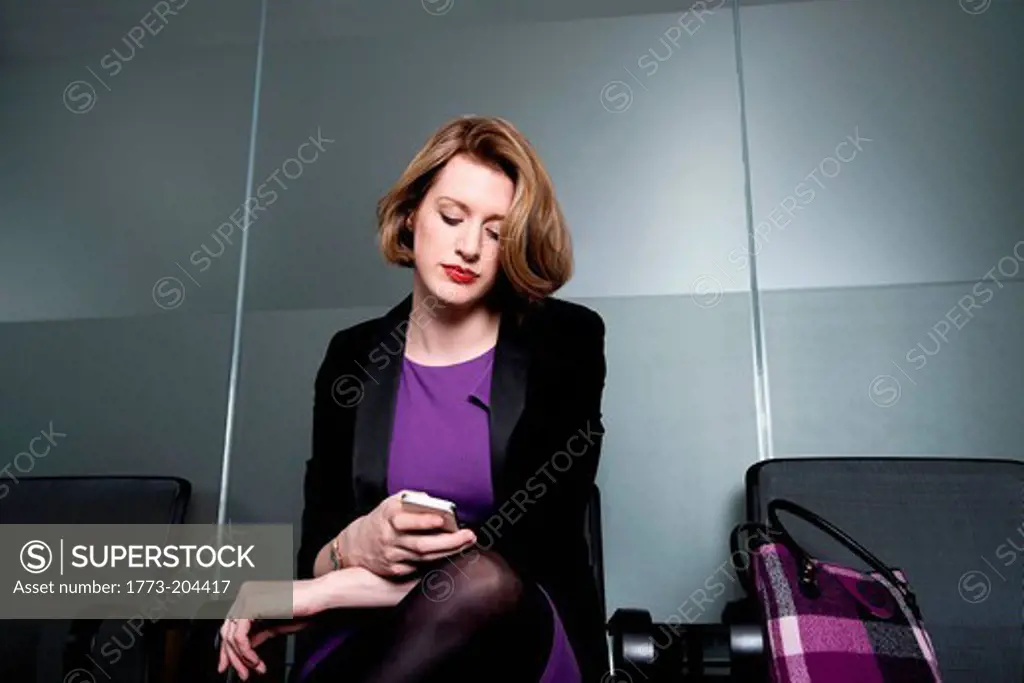 Business executive checking time or texting on smartphone