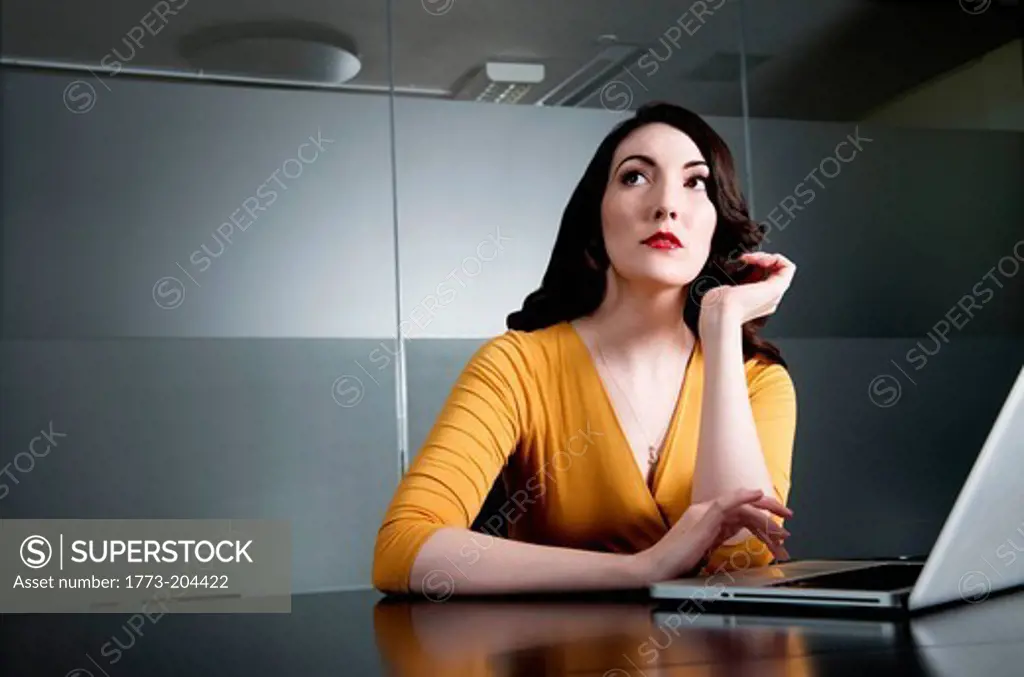 Woman looking up from laptop