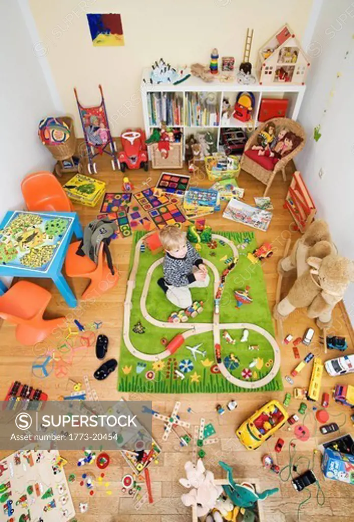 Boy plays in room crowded with toys