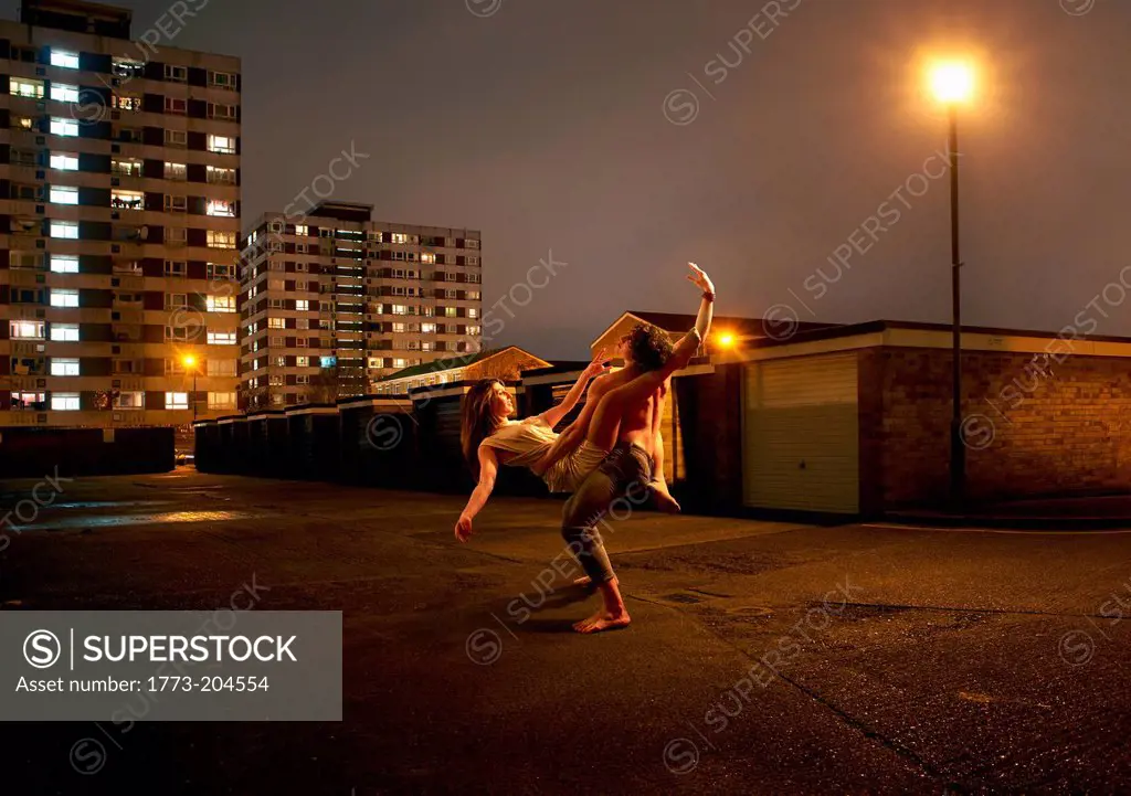 Young couple dancing in urban environment at night