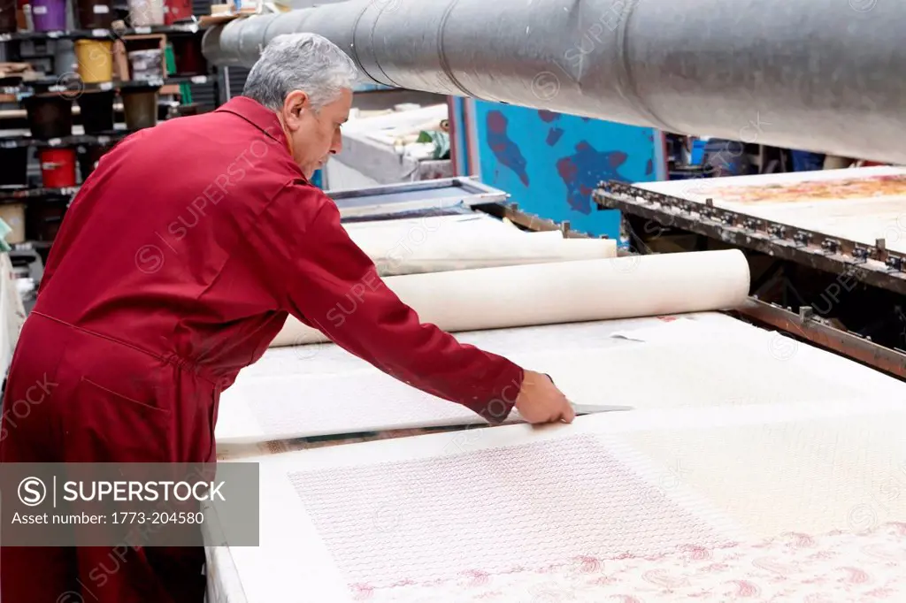 Man cutting fabric in textiles factory