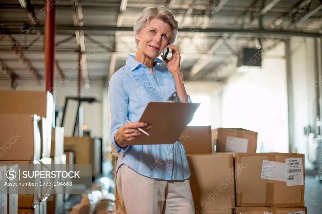 Female warehouse worker holding clipboard