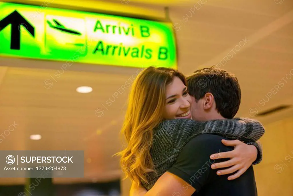 Young couple hugging in airport arrivals