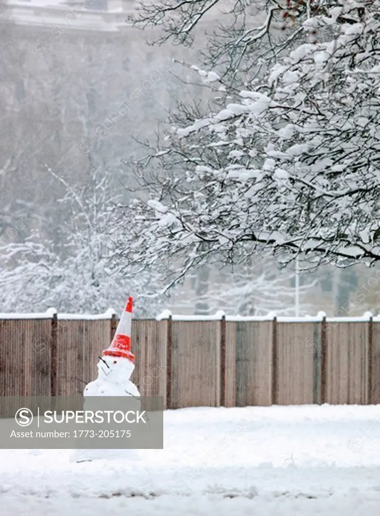 A snowman with a traffic cone on his head in St James Park, London, UK