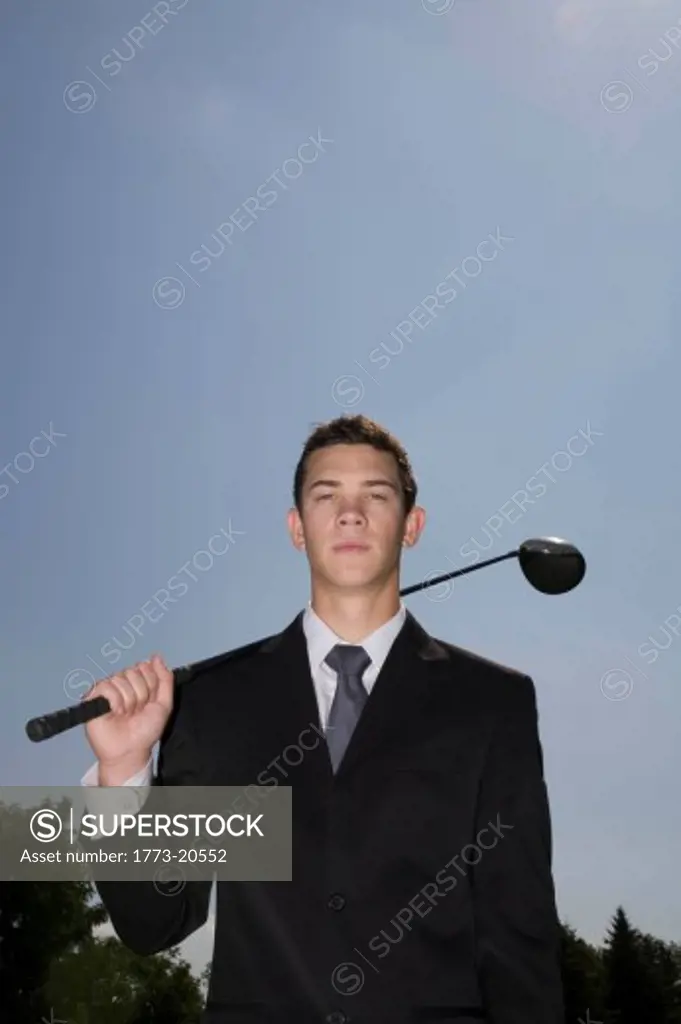 Man in business suit holding golf club