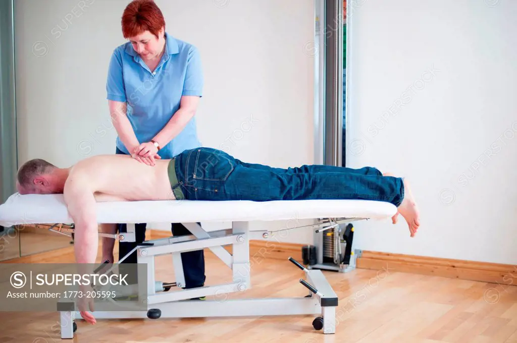 Man lying on front on massage table getting message
