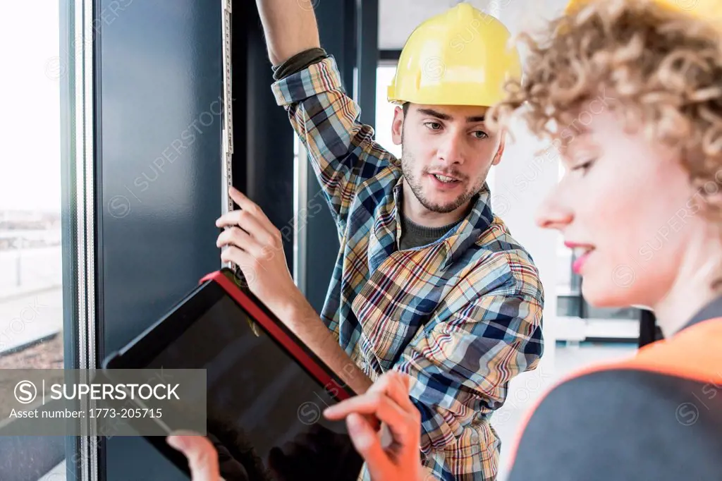 Builders using digital tablet inside new office development