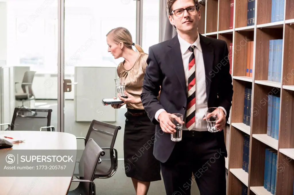 Lawyer leaving meeting room with drinking glasses