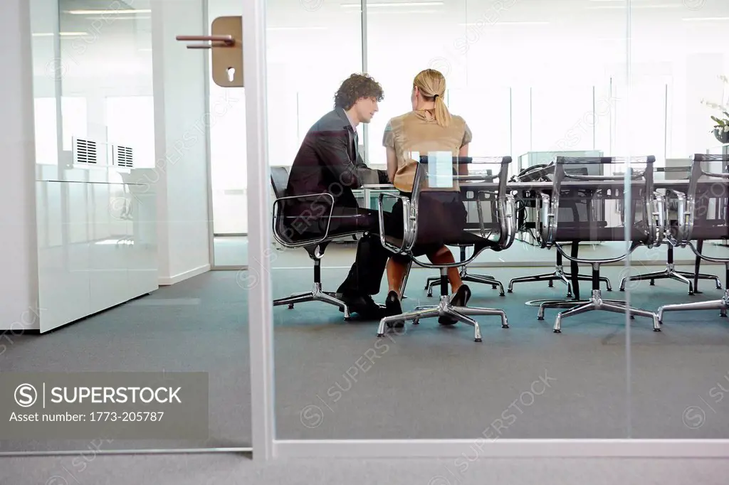 Businessman and woman having meeting at conference table