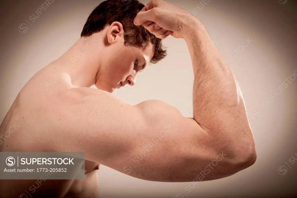 Side view of body builder flexing right arm