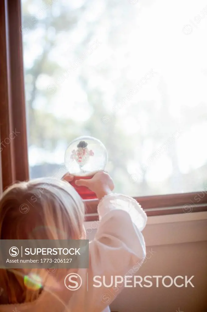 Girl playing with snow globe