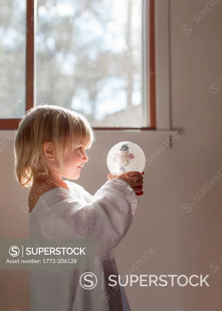 Girl playing with snow globe