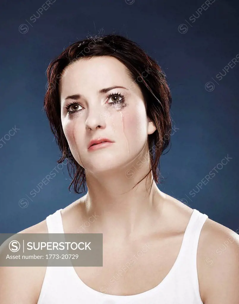 portrait of a girl crying on a blue background