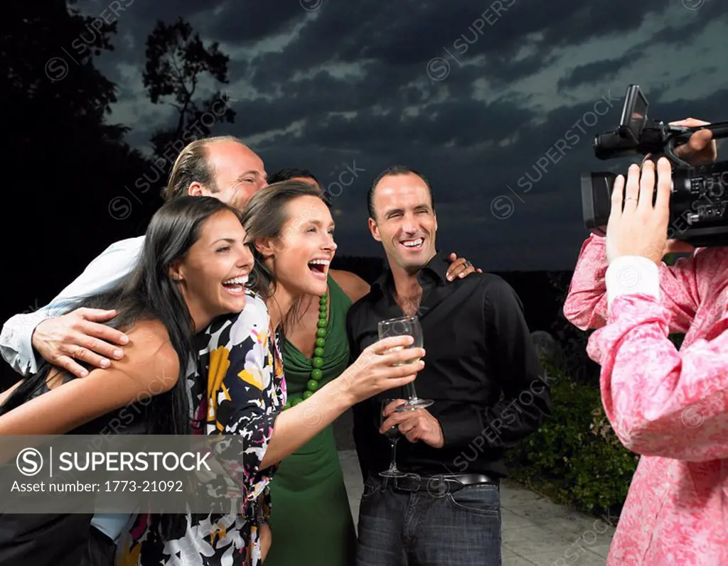 Man filming people at a cocktail party