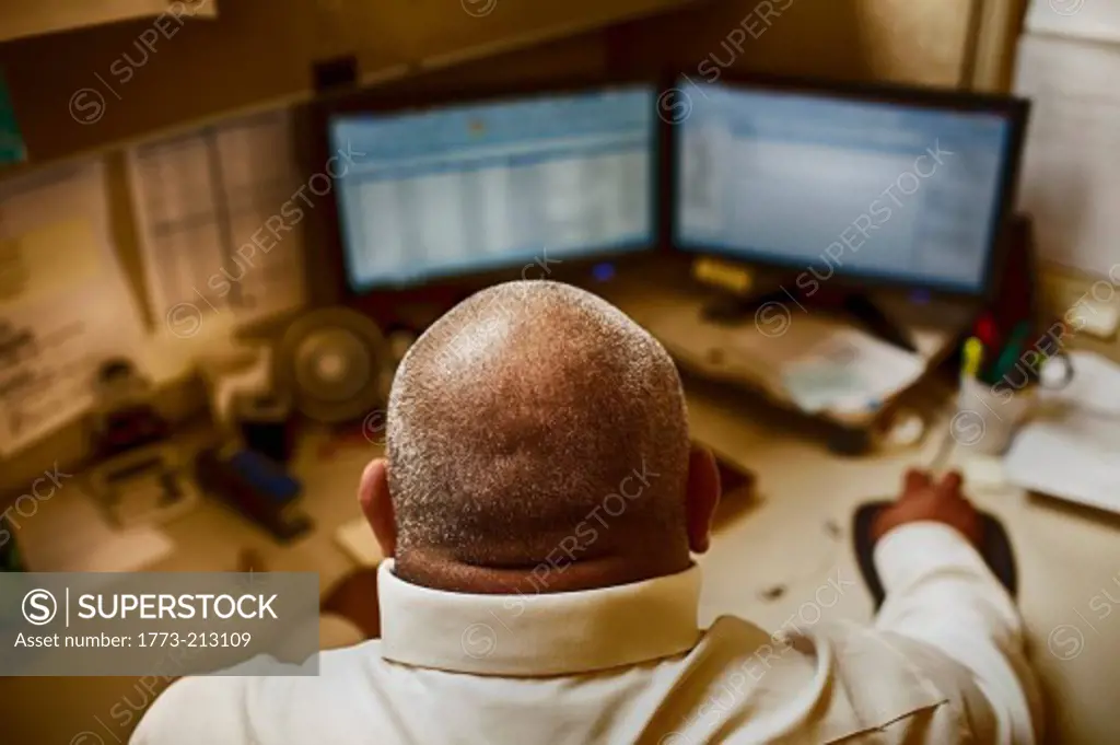 Mature man working in control room of manufacturing plant