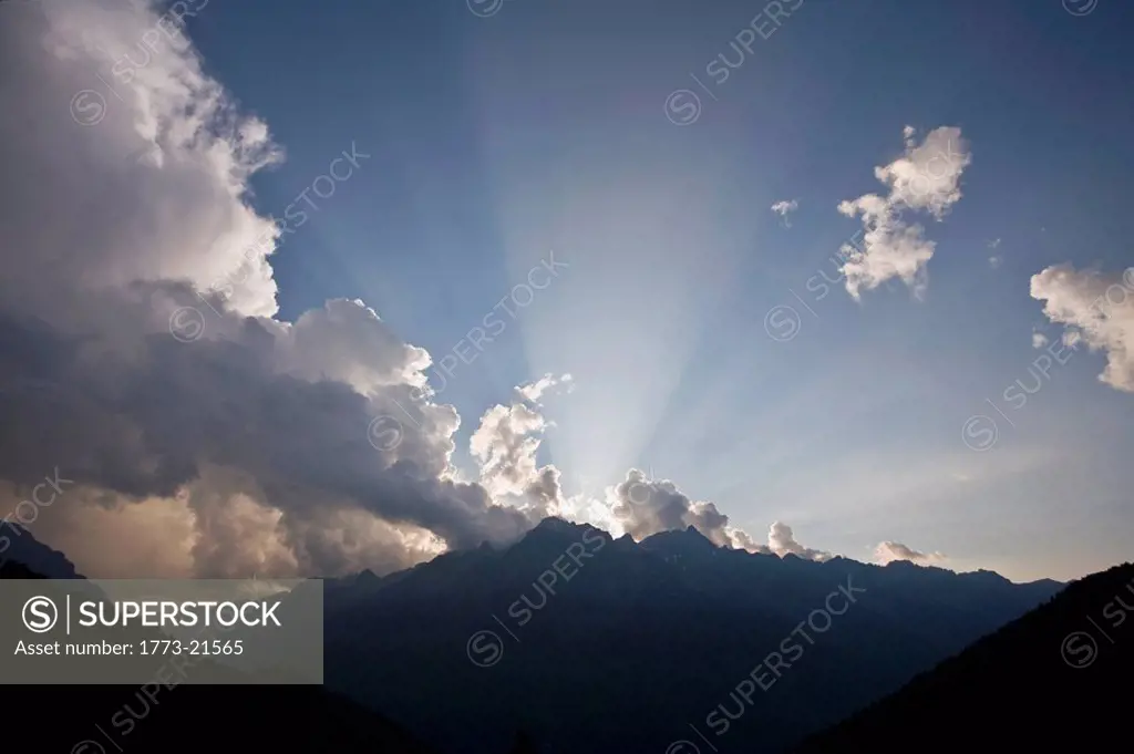 Biblical ray of sunlight piercing the sky over a mountain range.Take at sunset.Belledone moutain chain. Alps,France