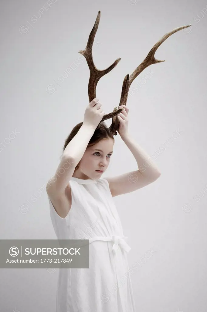Girl posing with antlers on head