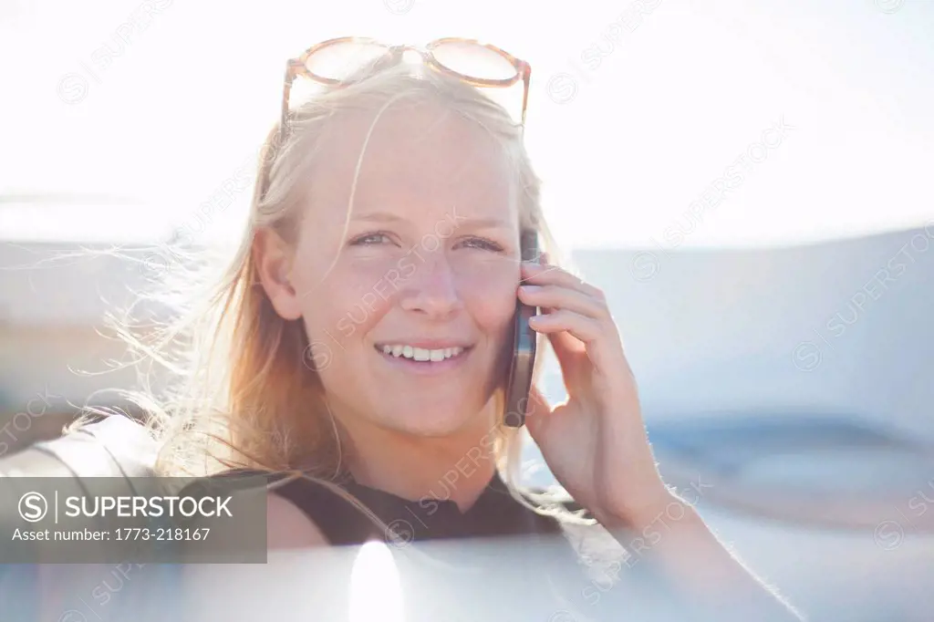 Woman on cell phone in yacht, Wales, UK