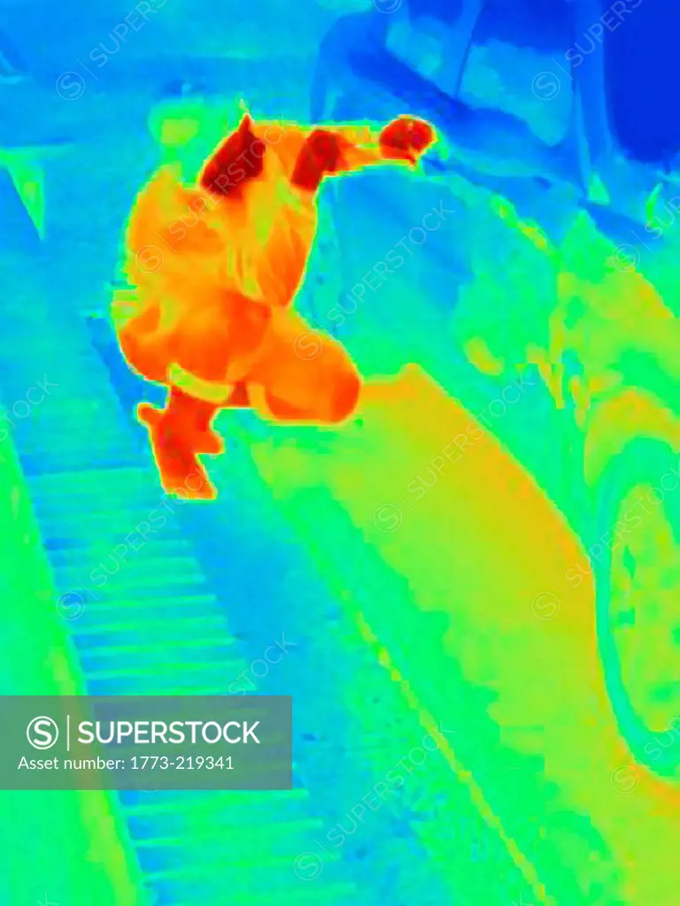 Thermal photograph of a burglar breaking into a car