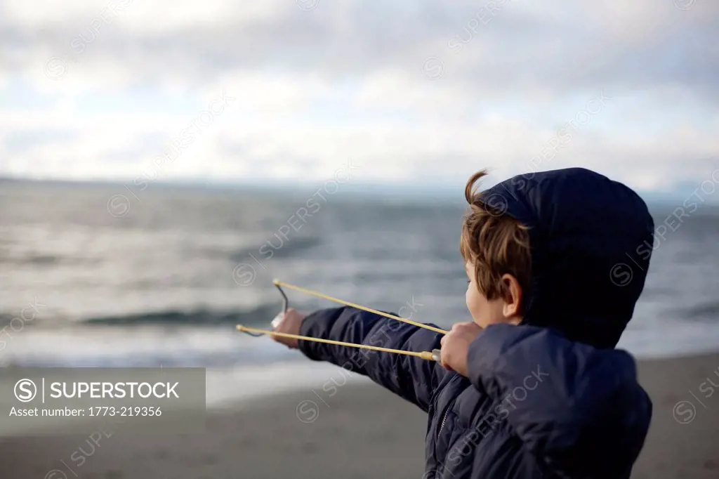 Boy catapulting rock out to sea