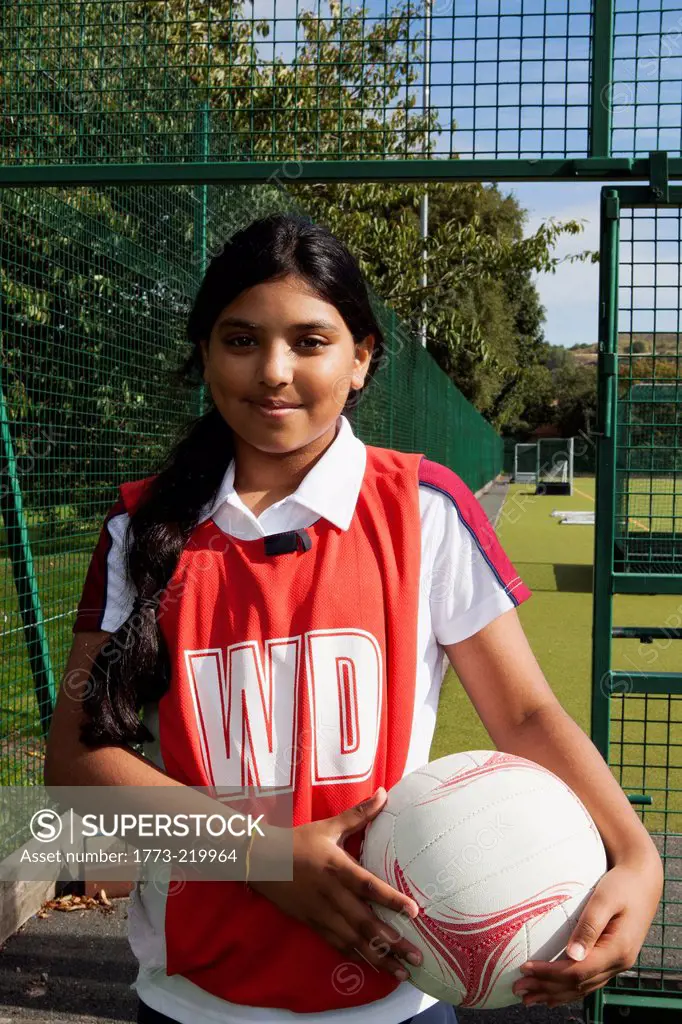 Portrait of schoolgirl netball player with ball