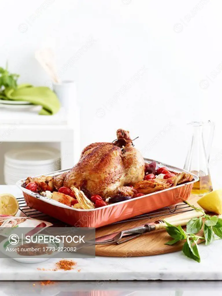 Roast chicken dish with vegetables, lemon and basil