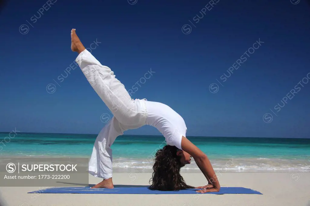 Young woman doing yoga on beach, Paradise Island, Nassau, Bahamas