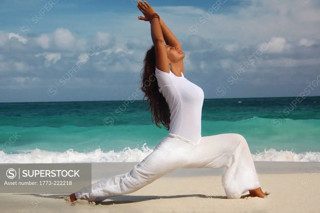 Female in warrior position on beach, Paradise Island, Nassau, Bahamas