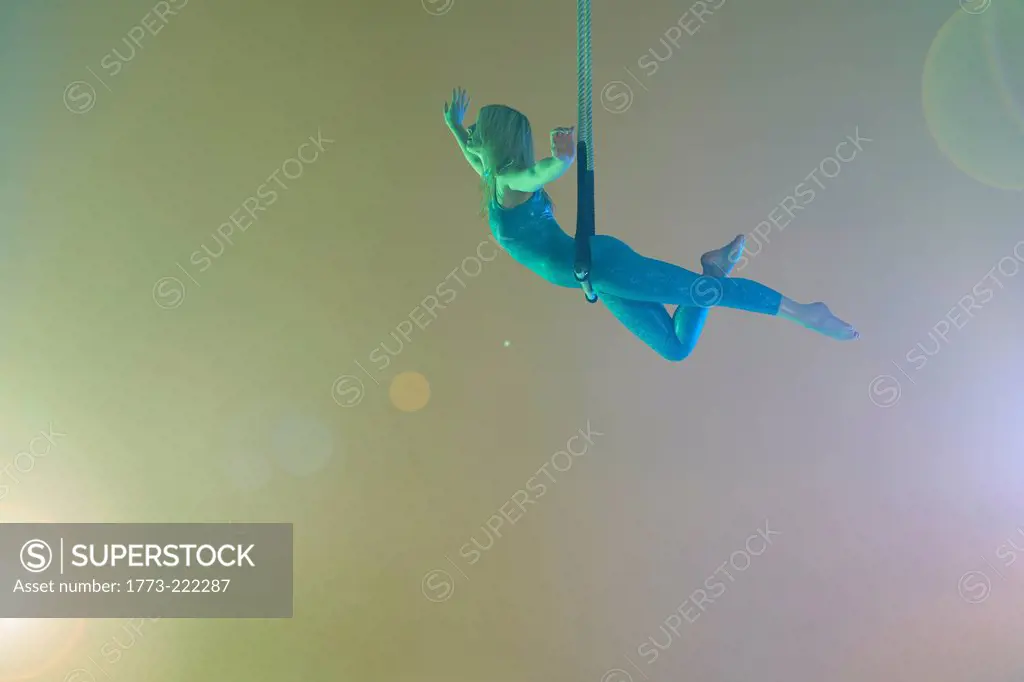 Trapeze artist balancing on trapeze