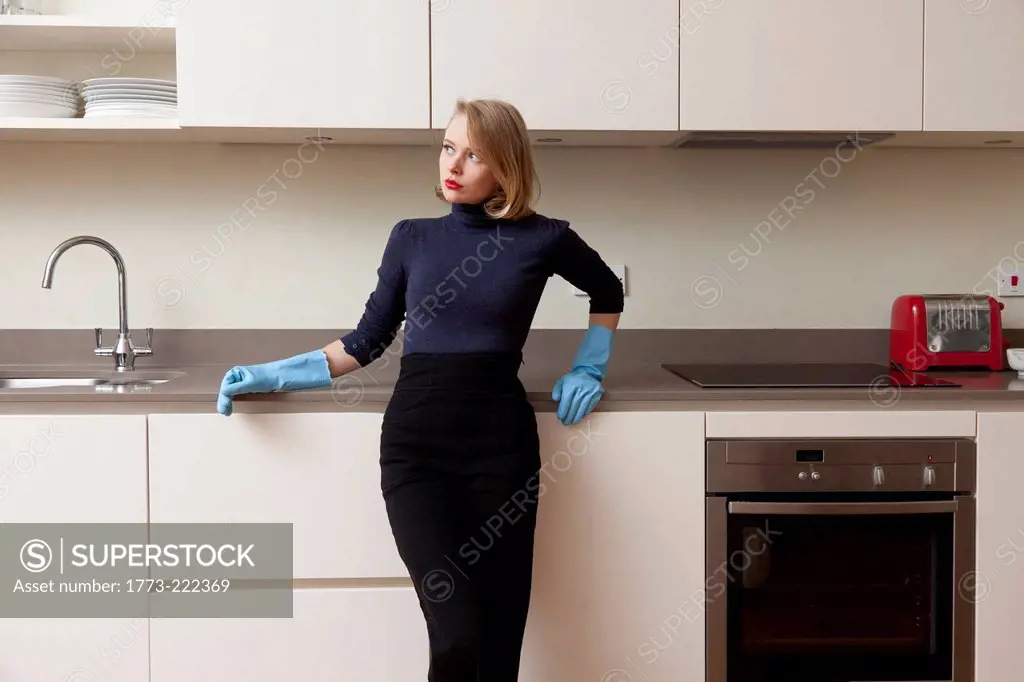 Woman leaning against kitchen cabinet