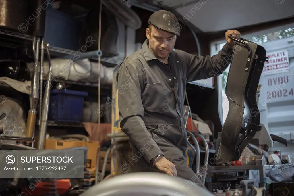 Mechanic in his garage converting gas powered motorcycles to Bio-Diesel