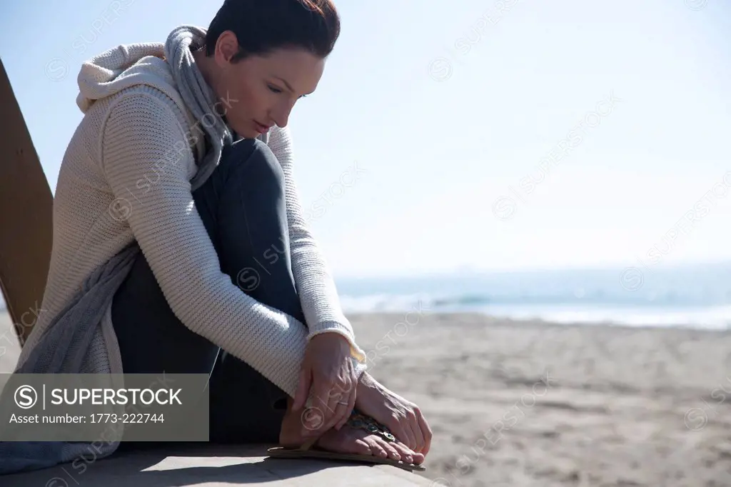 Mature woman sitting on Newport Beach, California, USA
